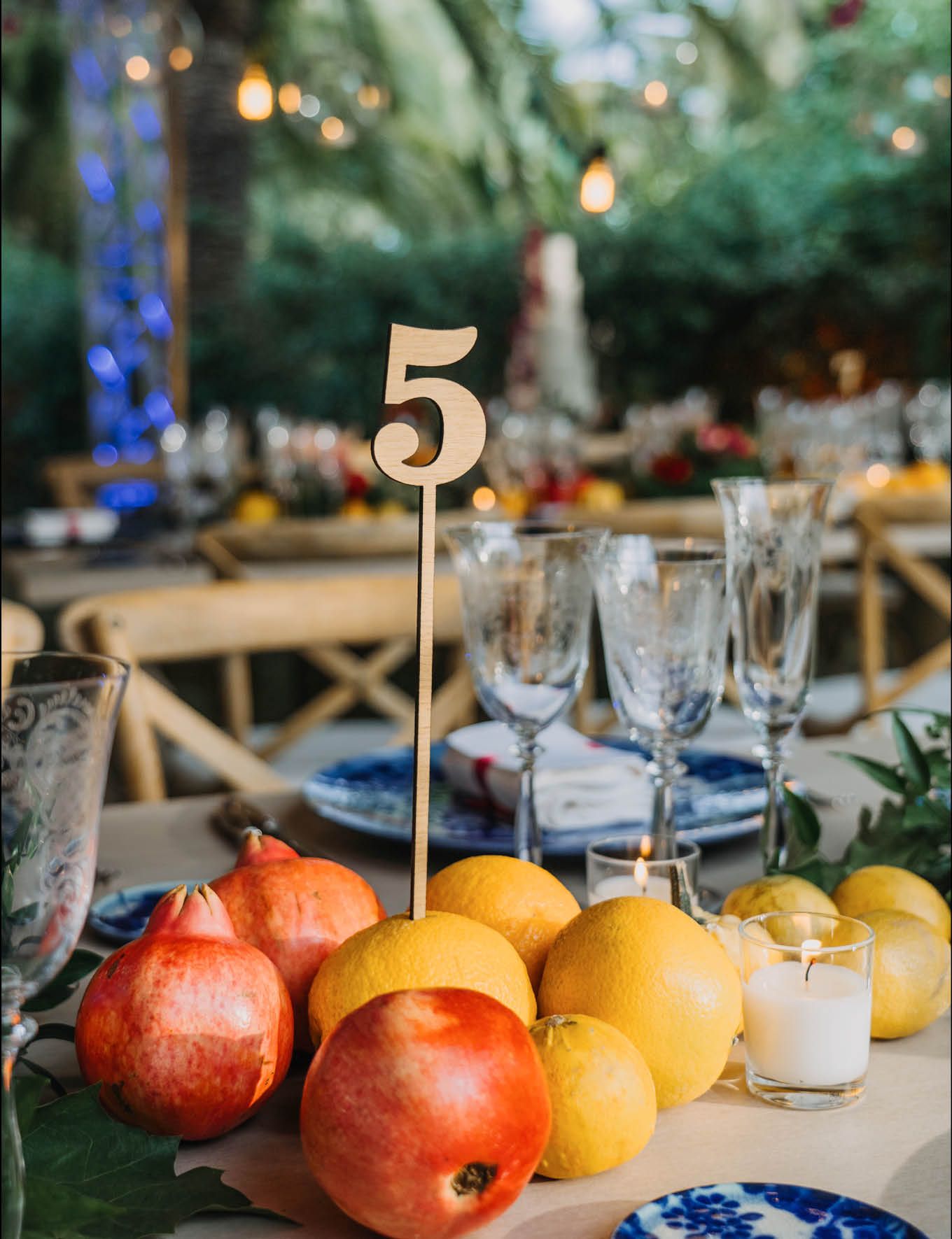 Wedding table setting with citrus fruit decor and table number five centerpiece.