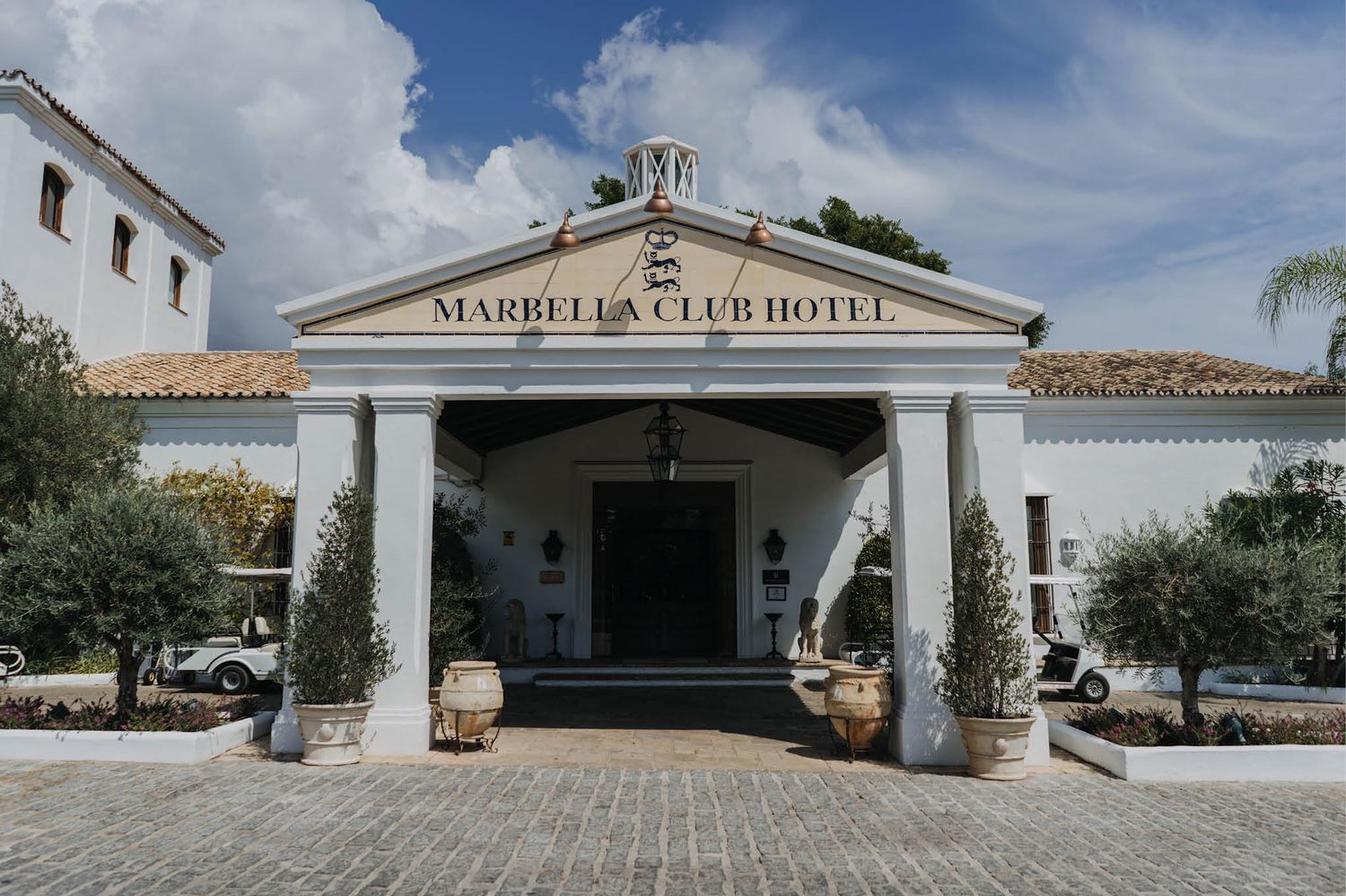 White columned entrance of Marbella Club Hotel with Mediterranean architecture.