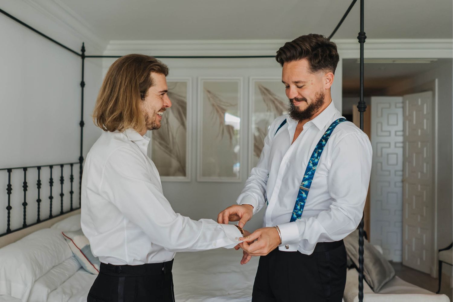 Two people helping with formal attire preparations indoors.