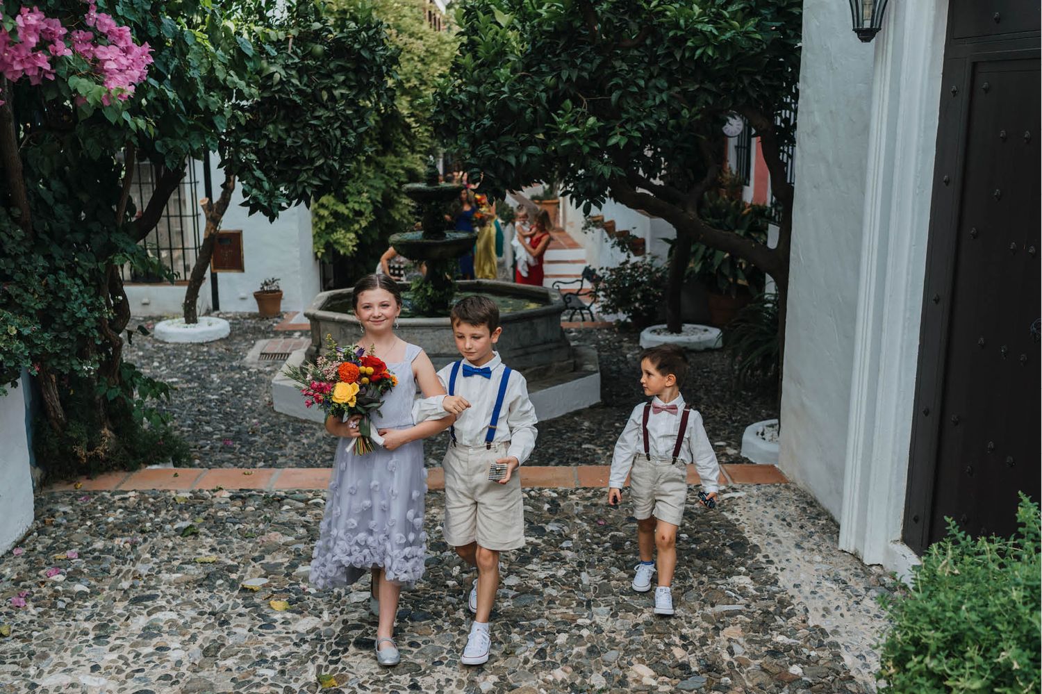 Children walking down a stone pathway at an outdoor wedding venue.