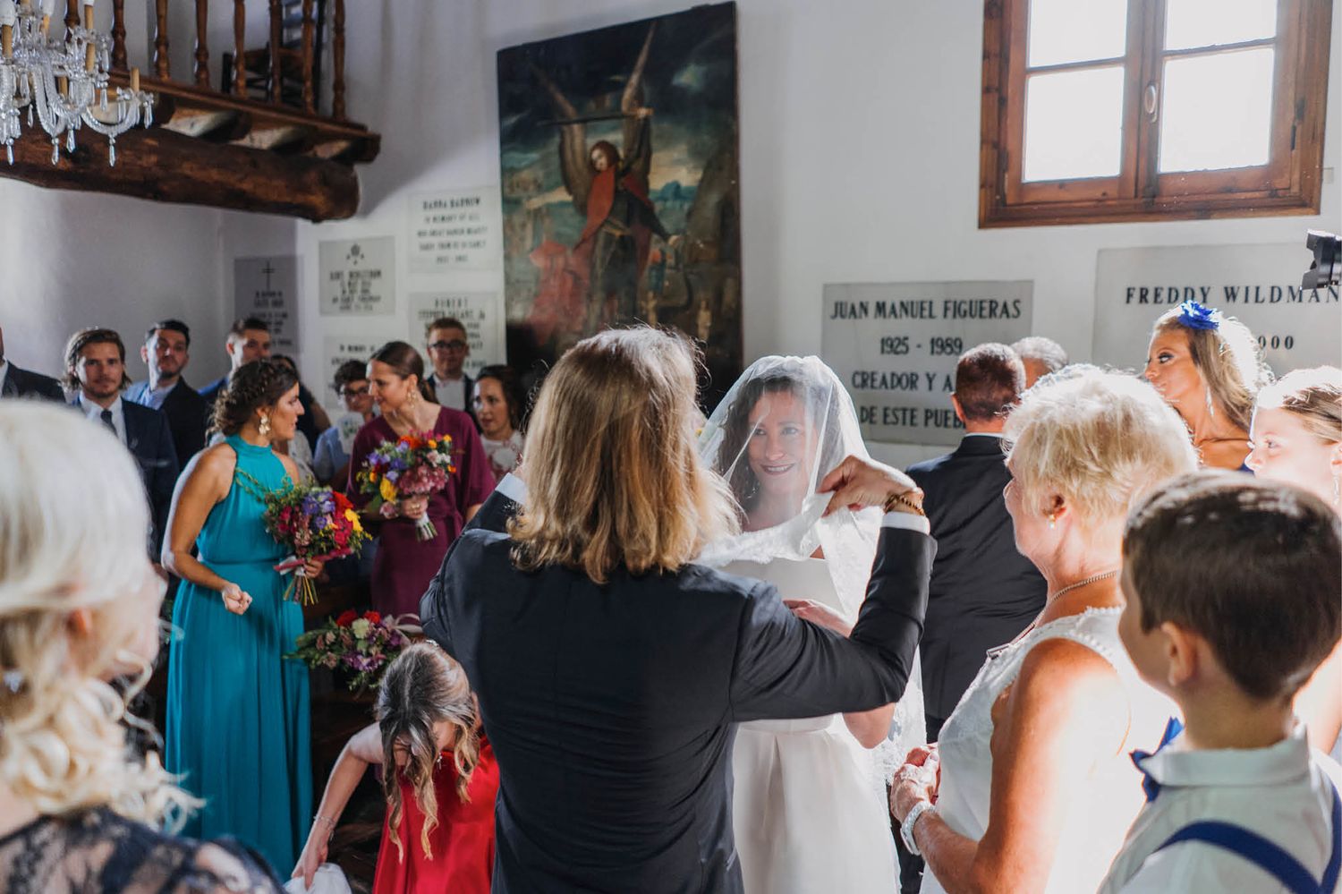 Wedding guests gather in a bright church interior during a celebration ceremony.