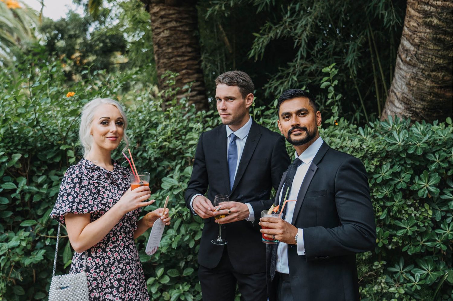 Guests enjoying drinks and conversation during an outdoor garden cocktail hour.