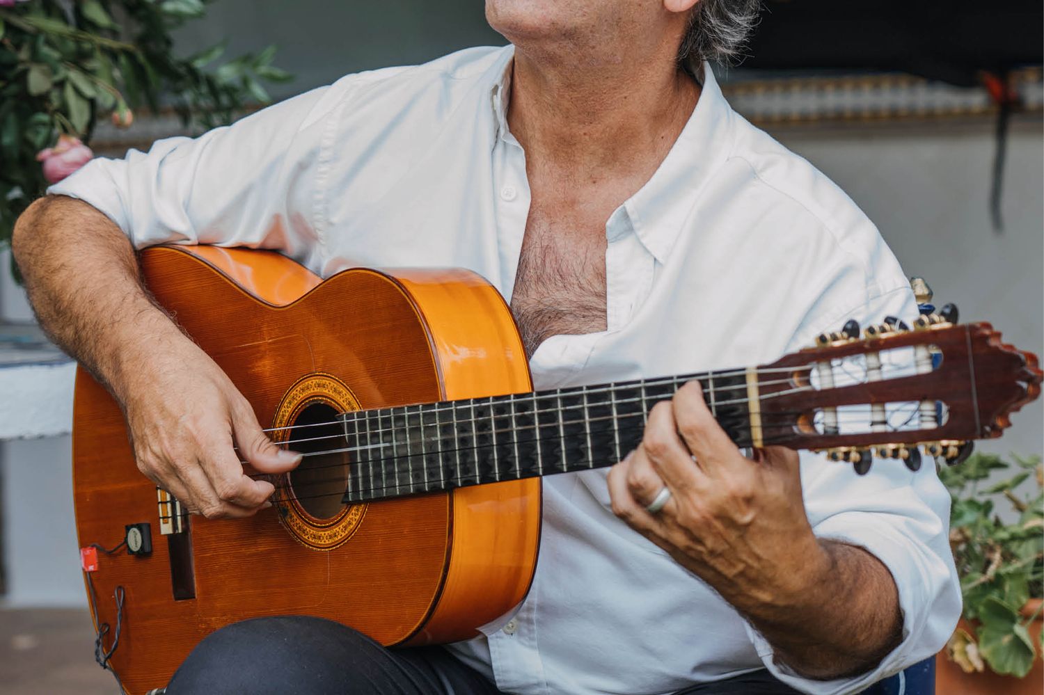 Musician playing classical guitar at an outdoor event.