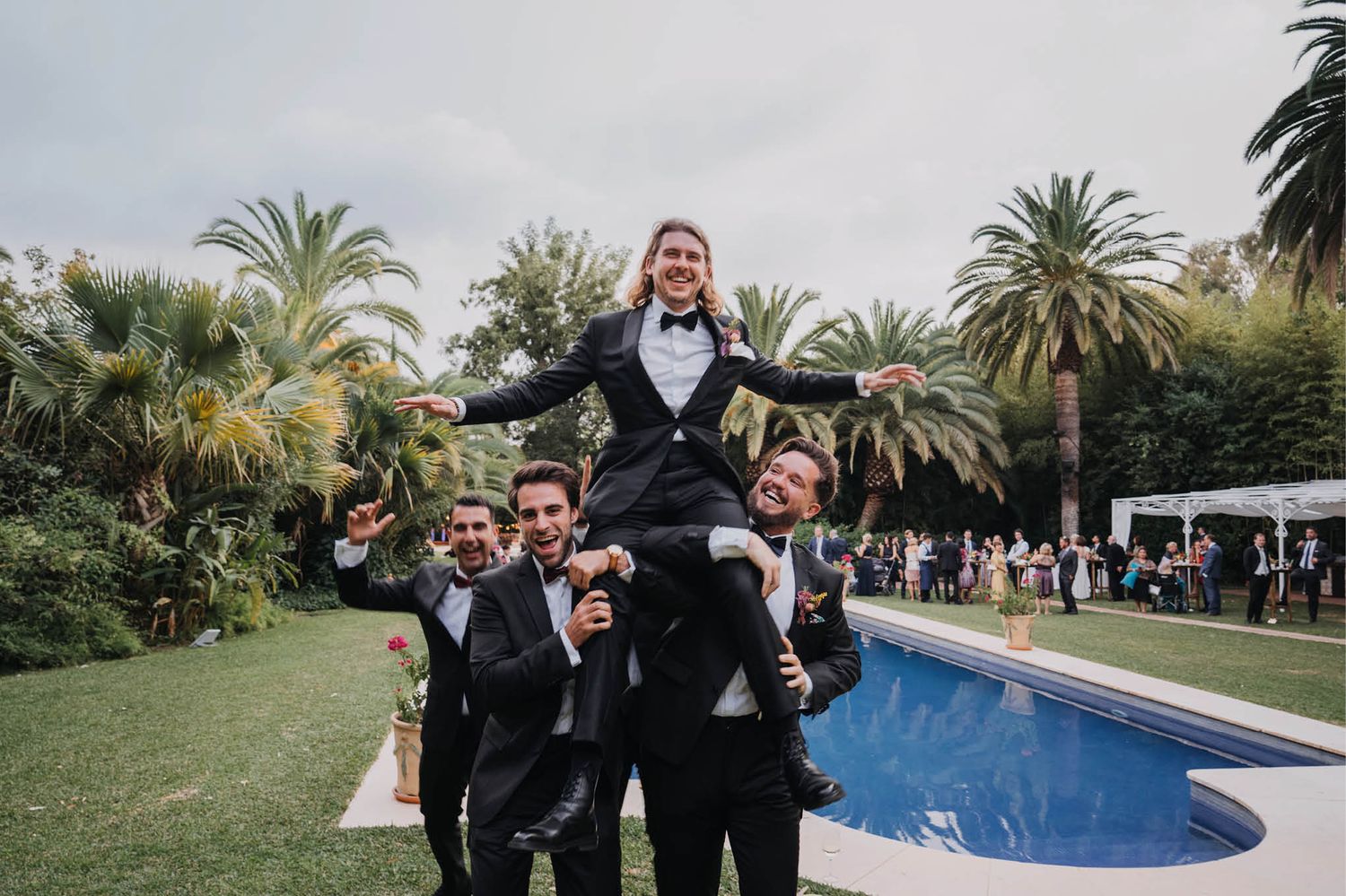 Celebratory moment at an outdoor wedding reception by the pool.
