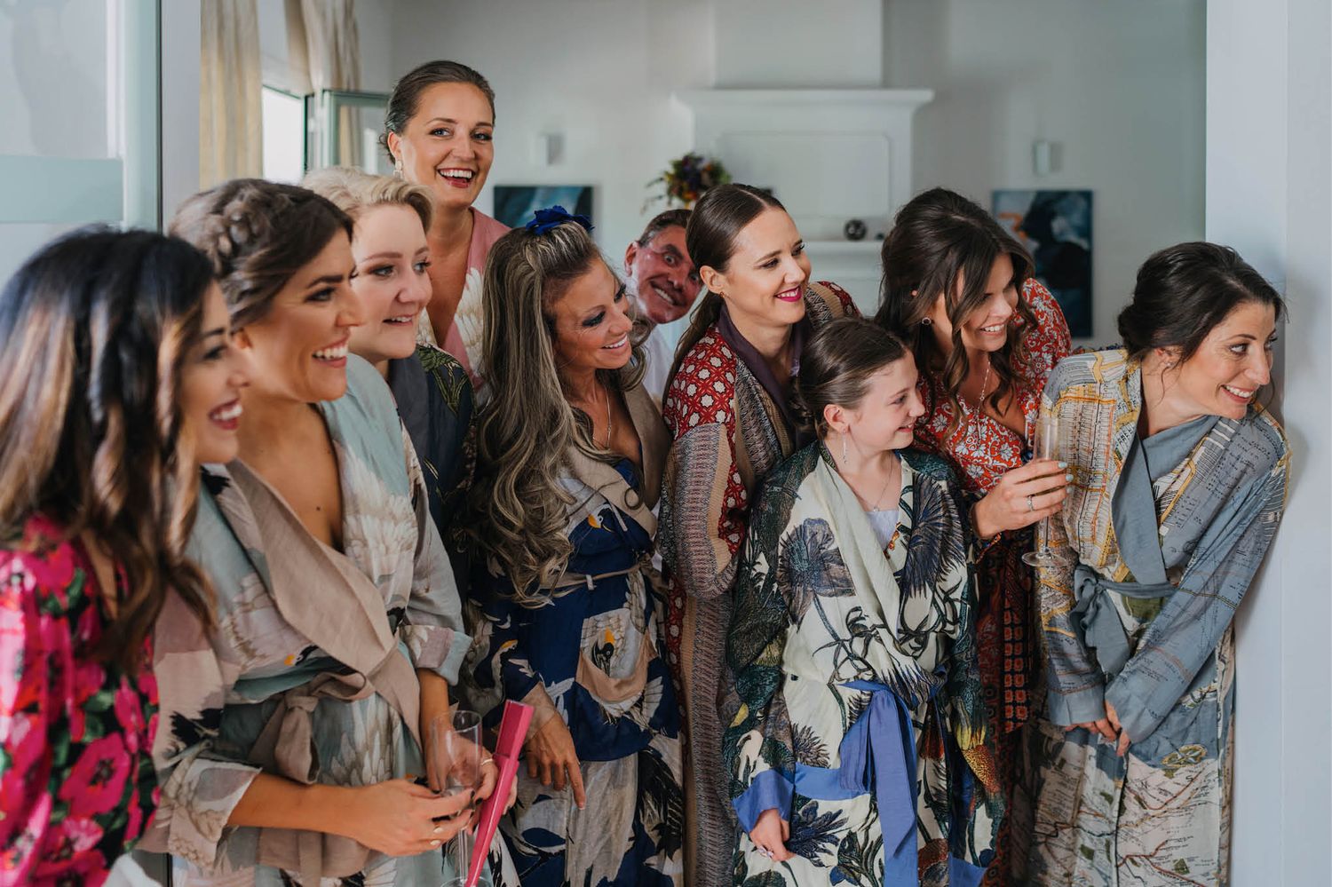 Candid joyful moment during wedding preparations with group in patterned robes.