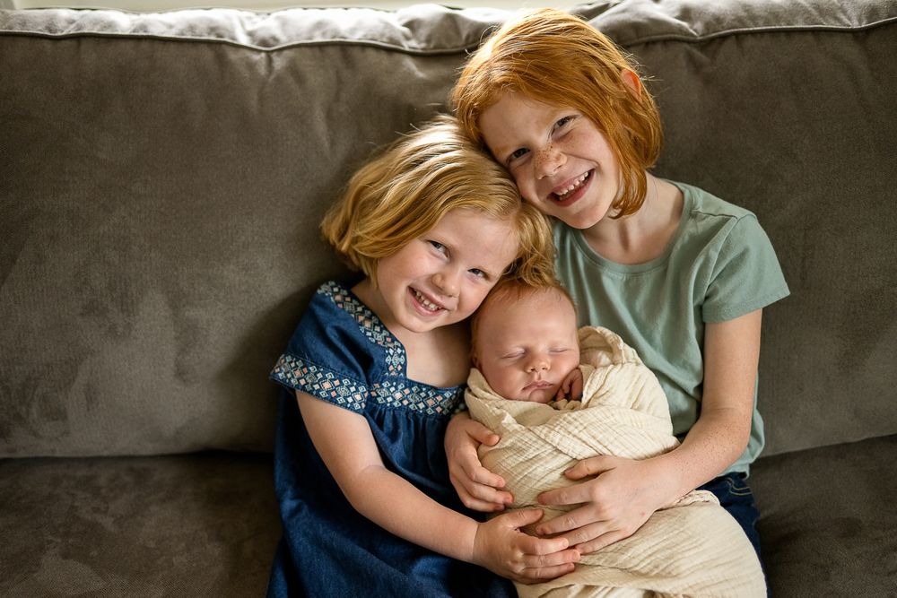 Children sharing sweet moments together on a couch.