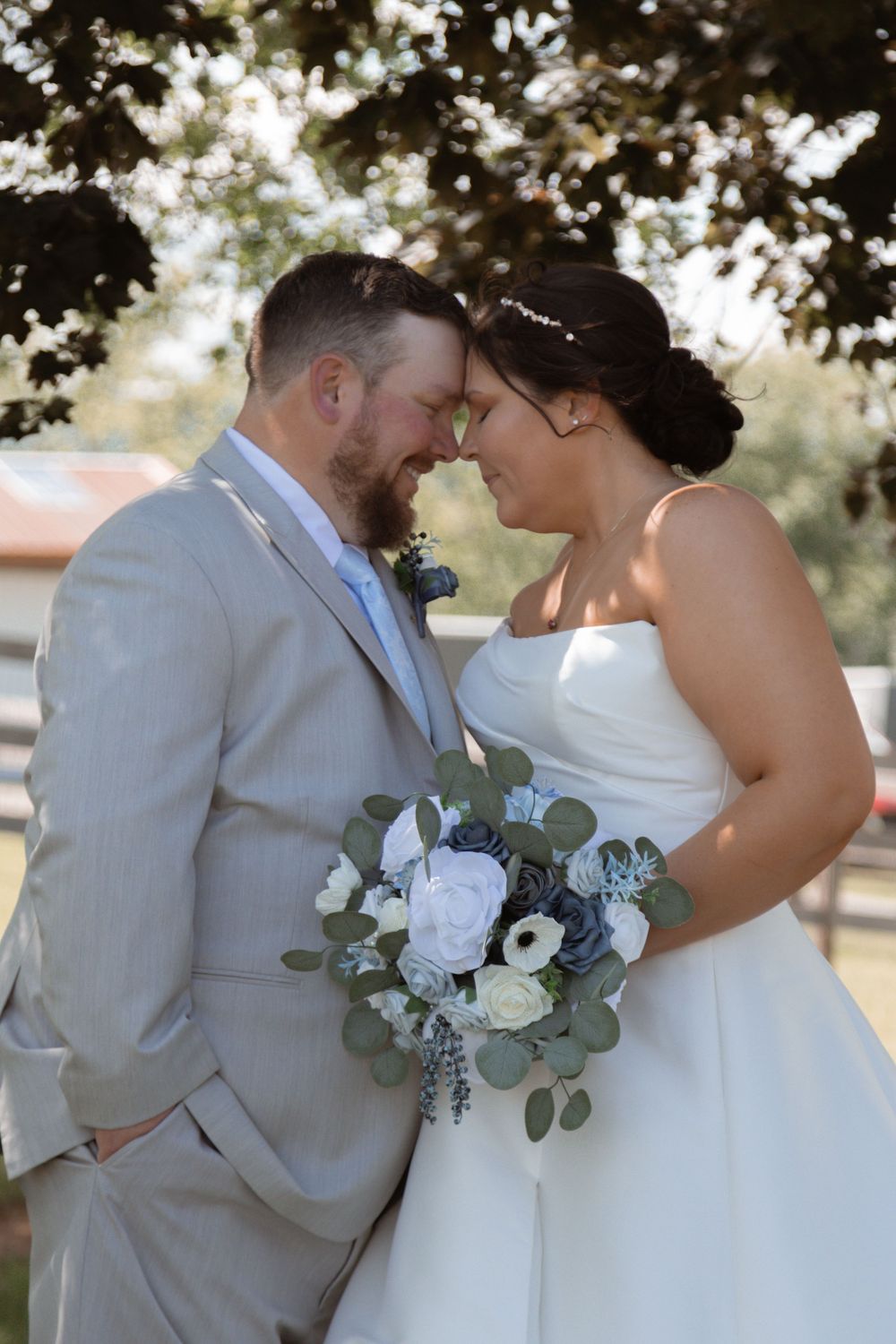 Intimate moment between newlyweds sharing a romantic moment with white floral bouquet.