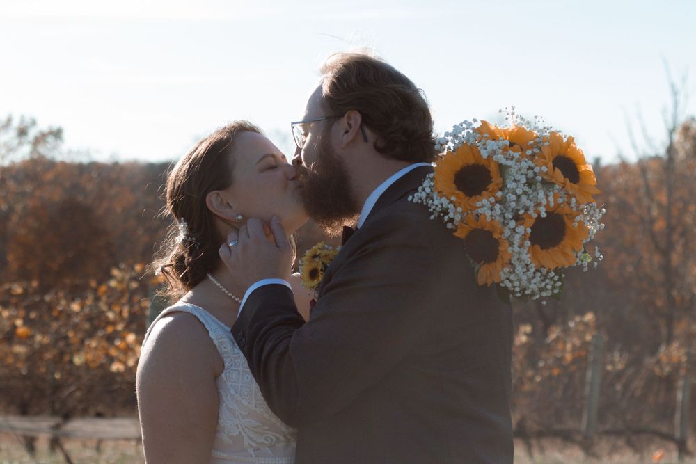 Autumn wedding photoshoot featuring couple embracing in vineyard setting.