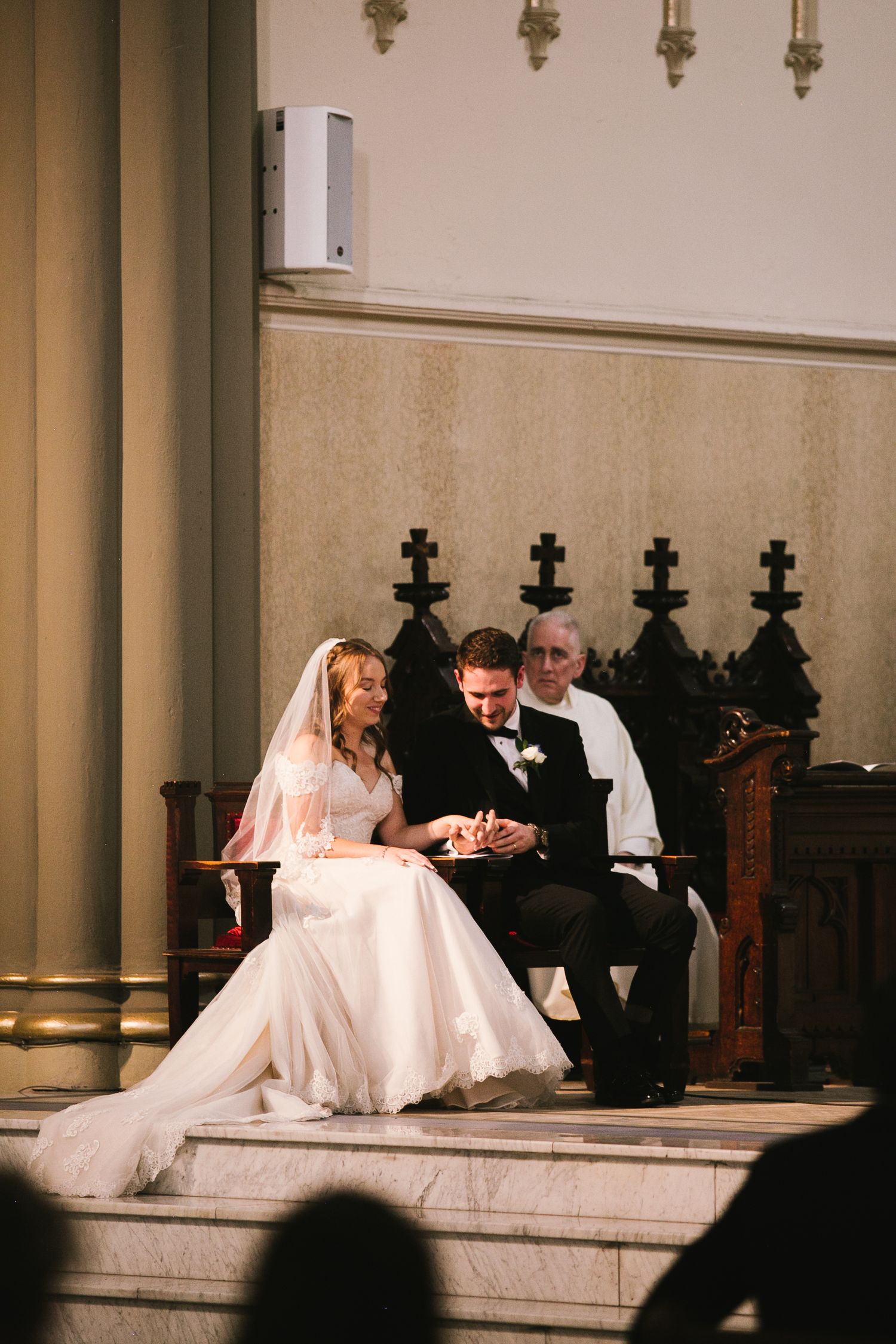 Wedding ceremony moment captured on church steps with elegant decor and lighting.