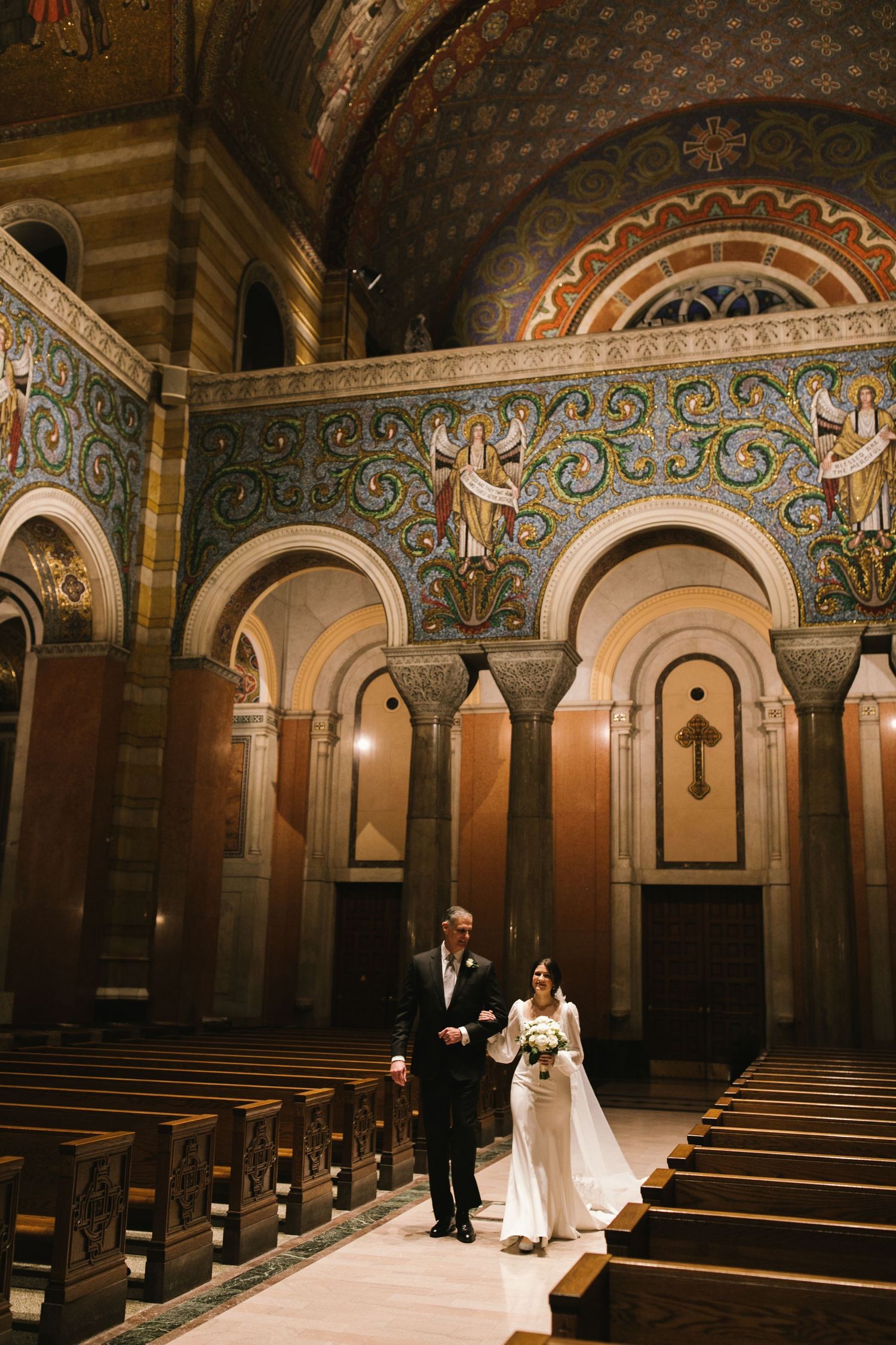 Cathedral wedding portrait showcasing ornate mosaic walls and arched architecture.