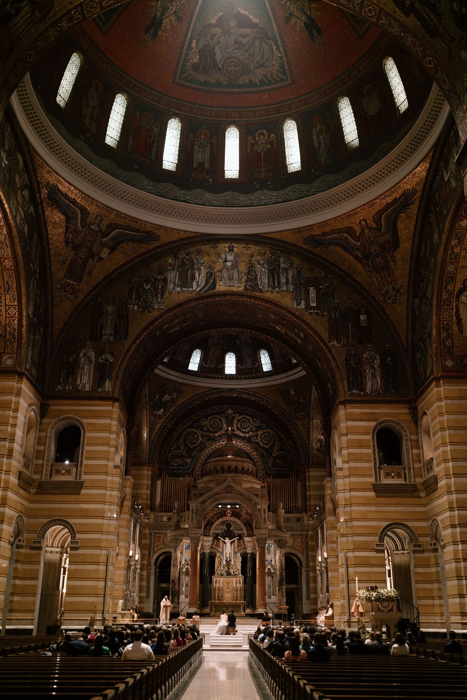 Stunning interior of a cathedral with domed ceiling, arches and ornate religious artwork.