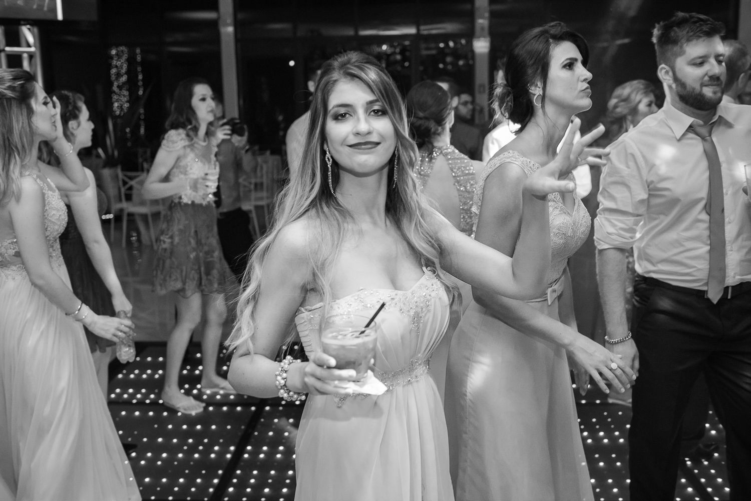 Bridesmaid in a flowing dress enjoys dancing at an elegant wedding reception.