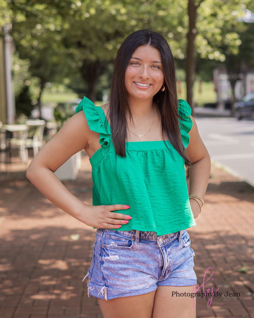 Woman in green ruffle top and denim shorts poses outdoors across multiple shots showing different angles and expressions.