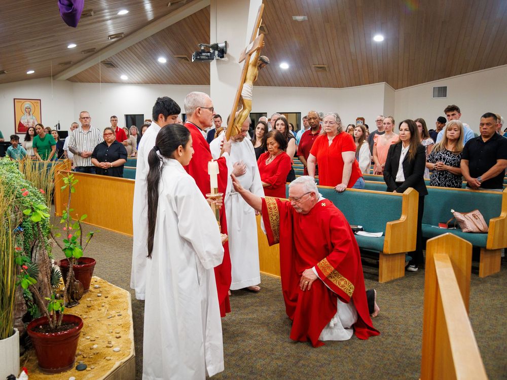 Religious ceremony taking place inside a church with participants in white and red robes during a traditional service.