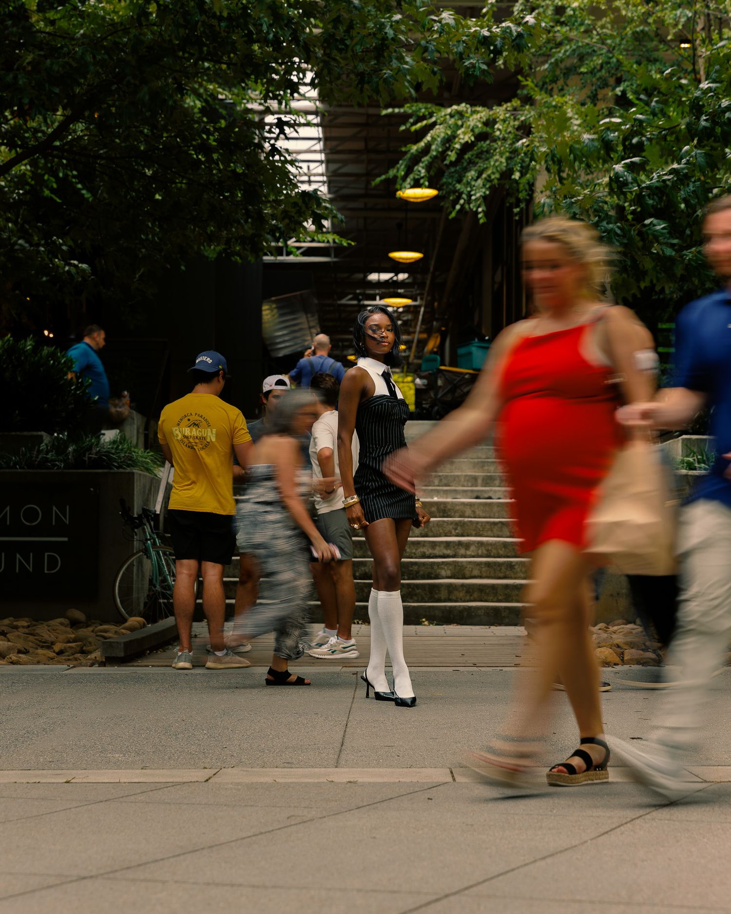 Blurred motion of people walking on urban steps with pedestrians in background.