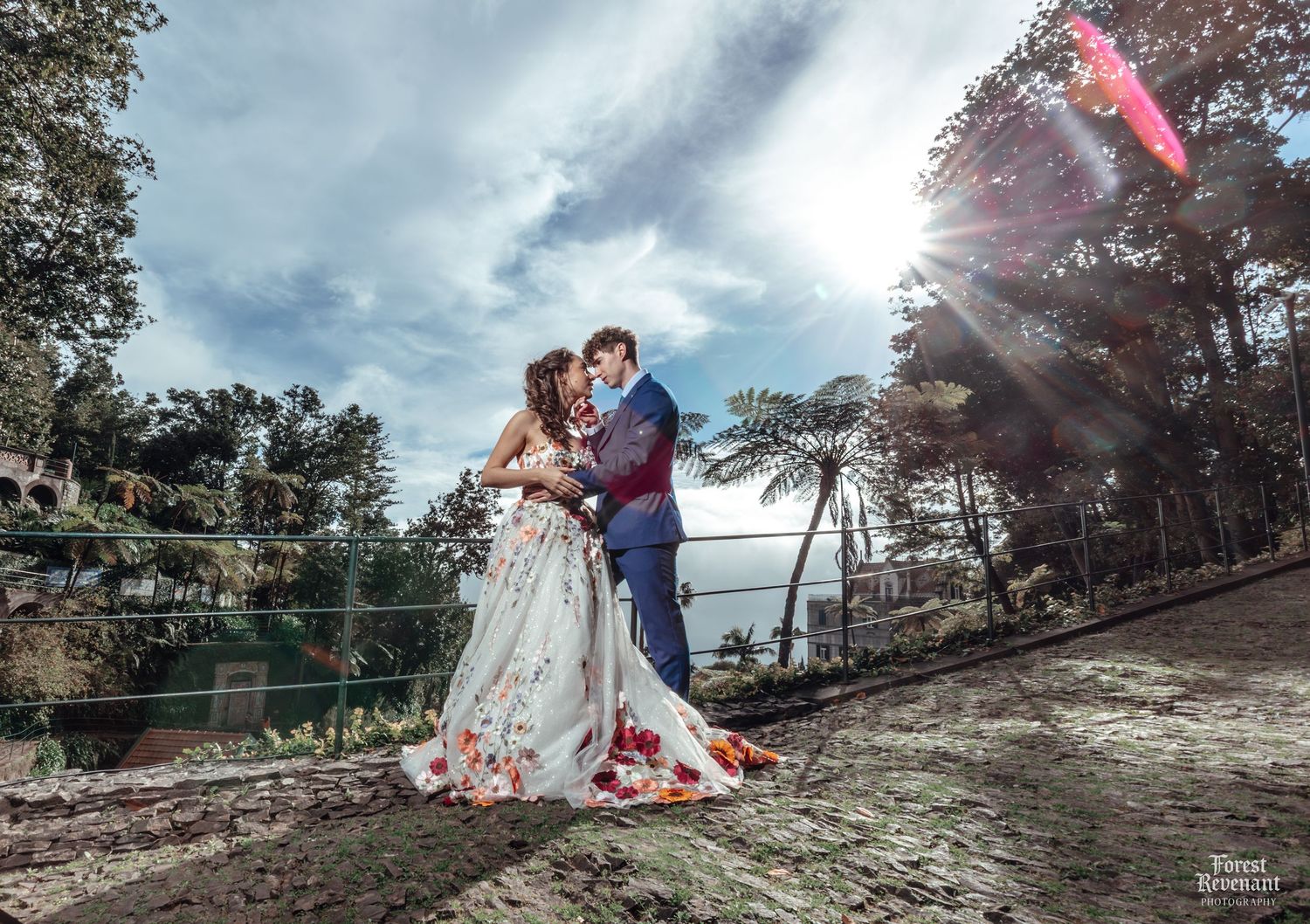 Wedding couple photography session on a rocky terrain with scattered rose petals and dramatic sky.