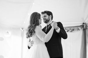 Bride and groom sharing their first dance in black and white at their elegant wedding reception.