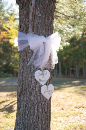 Wedding tree decoration with white tulle bow and wooden heart signs reading Jebediah and Rebecca Johnson.