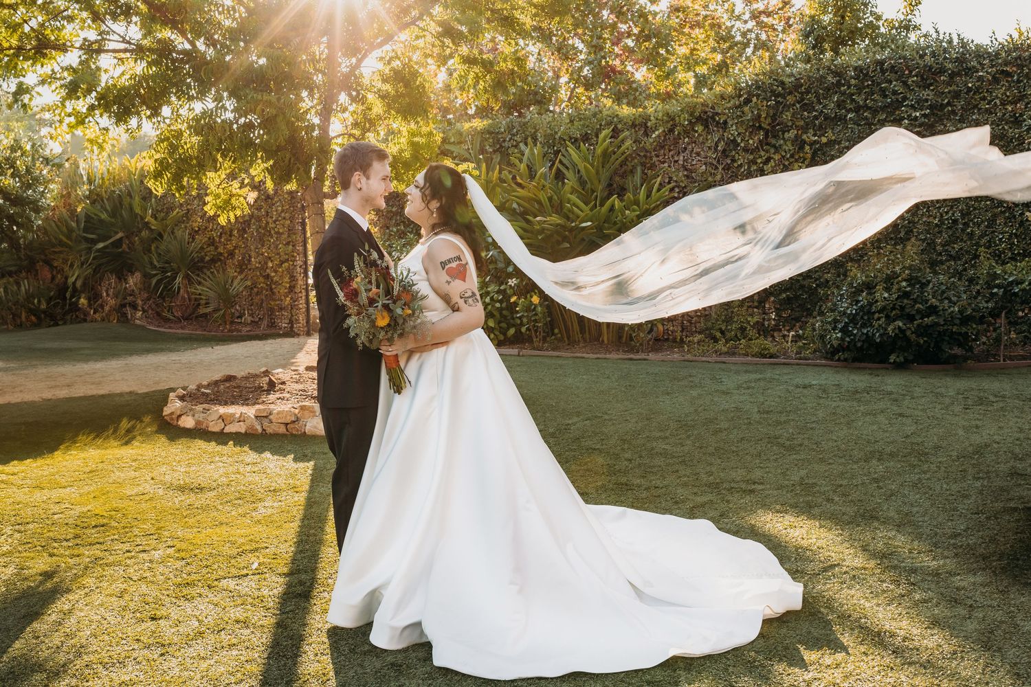 A man and women wearing wedding attire face each other during golden hour in Vista, California.