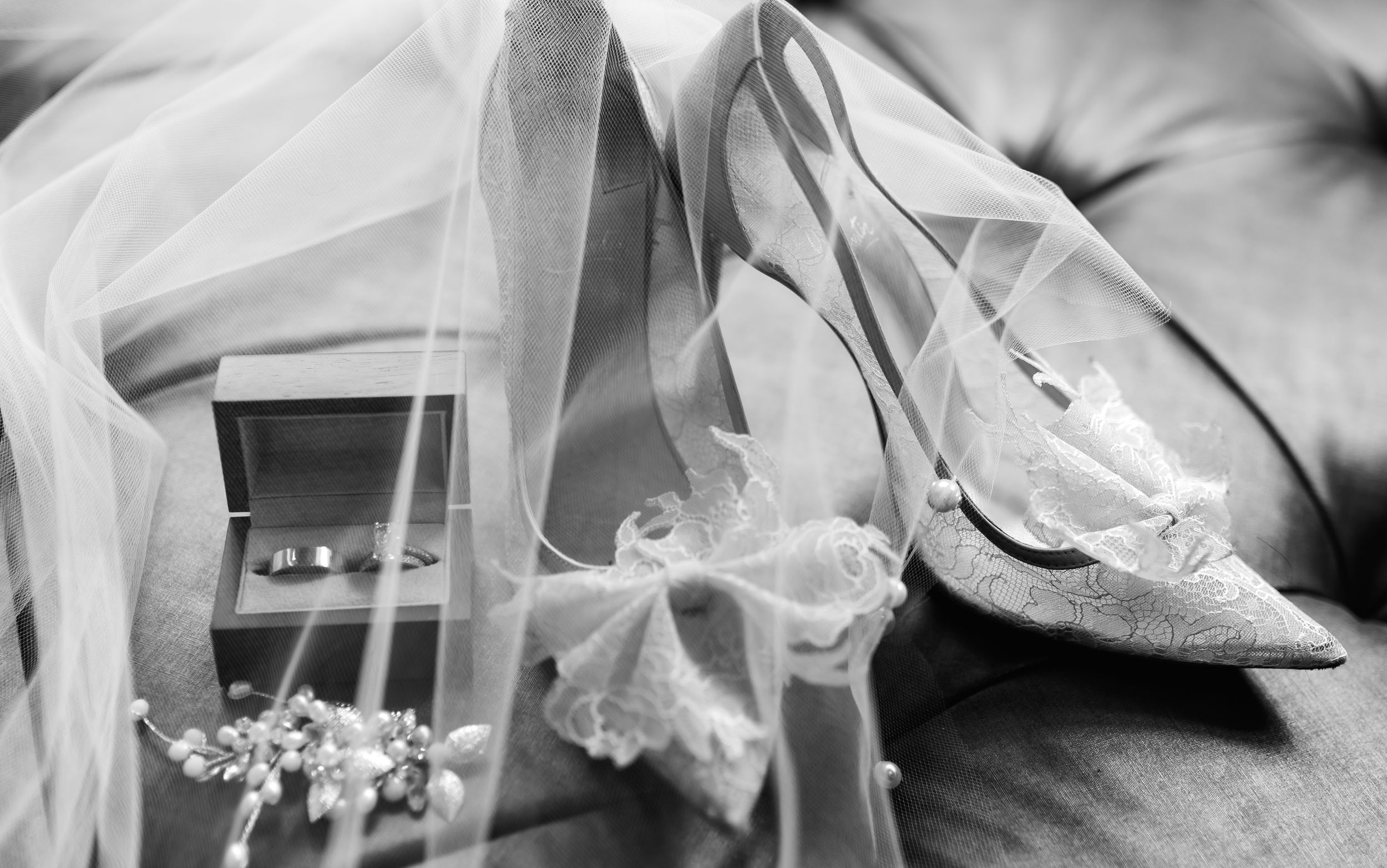 Wedding shoes and veil arranged in delicate still life composition.