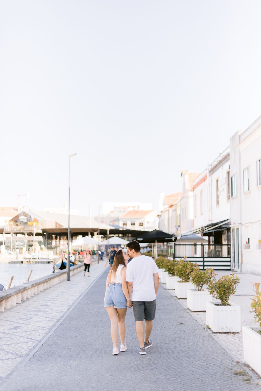 Sessão fotográfica de casal em aveiro, casal a caminhar de mãos dadas junto à ria de aveiro