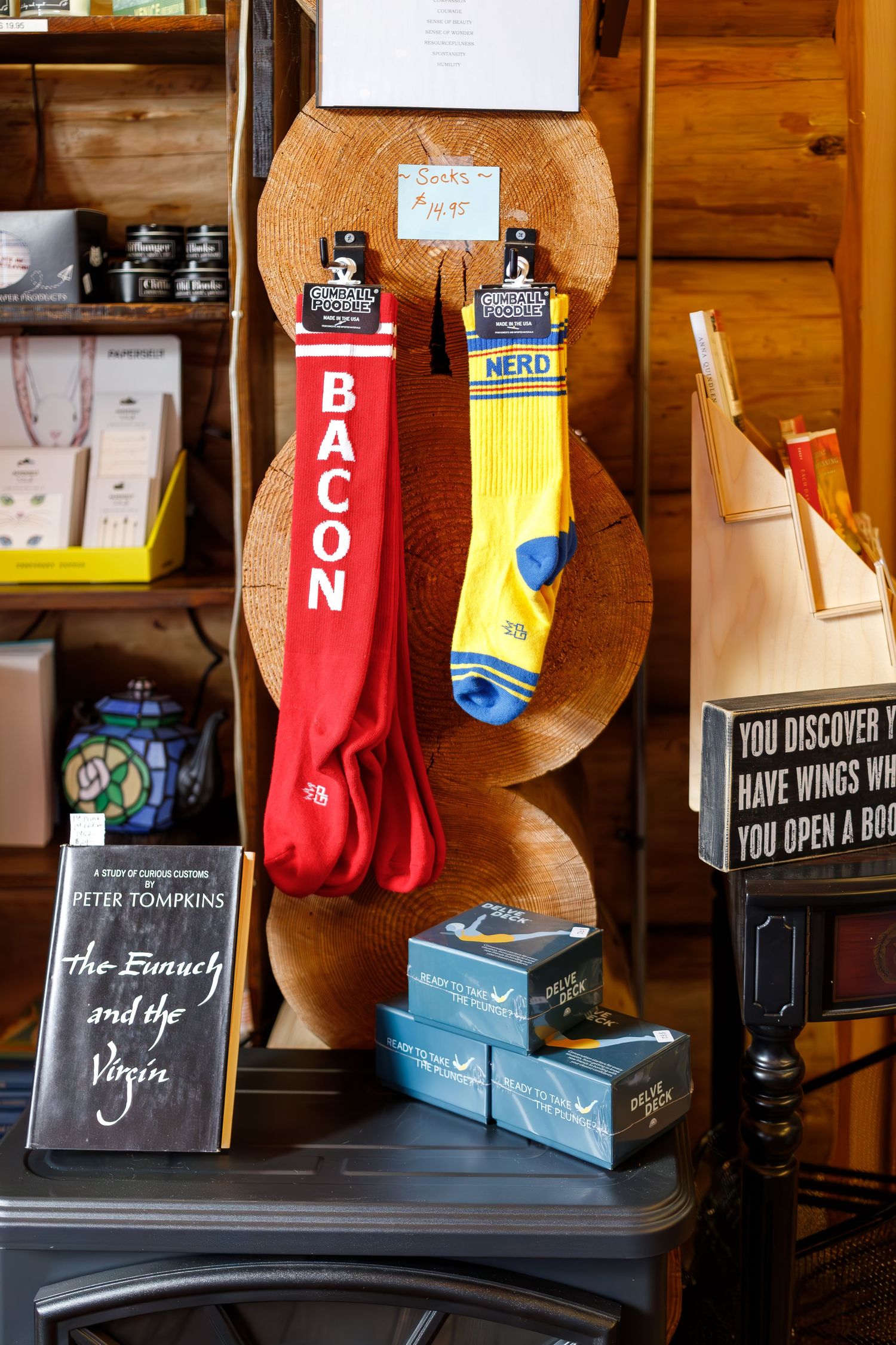 Red bacon and yellow socks displayed on wooden decor piece with various items on shelf.