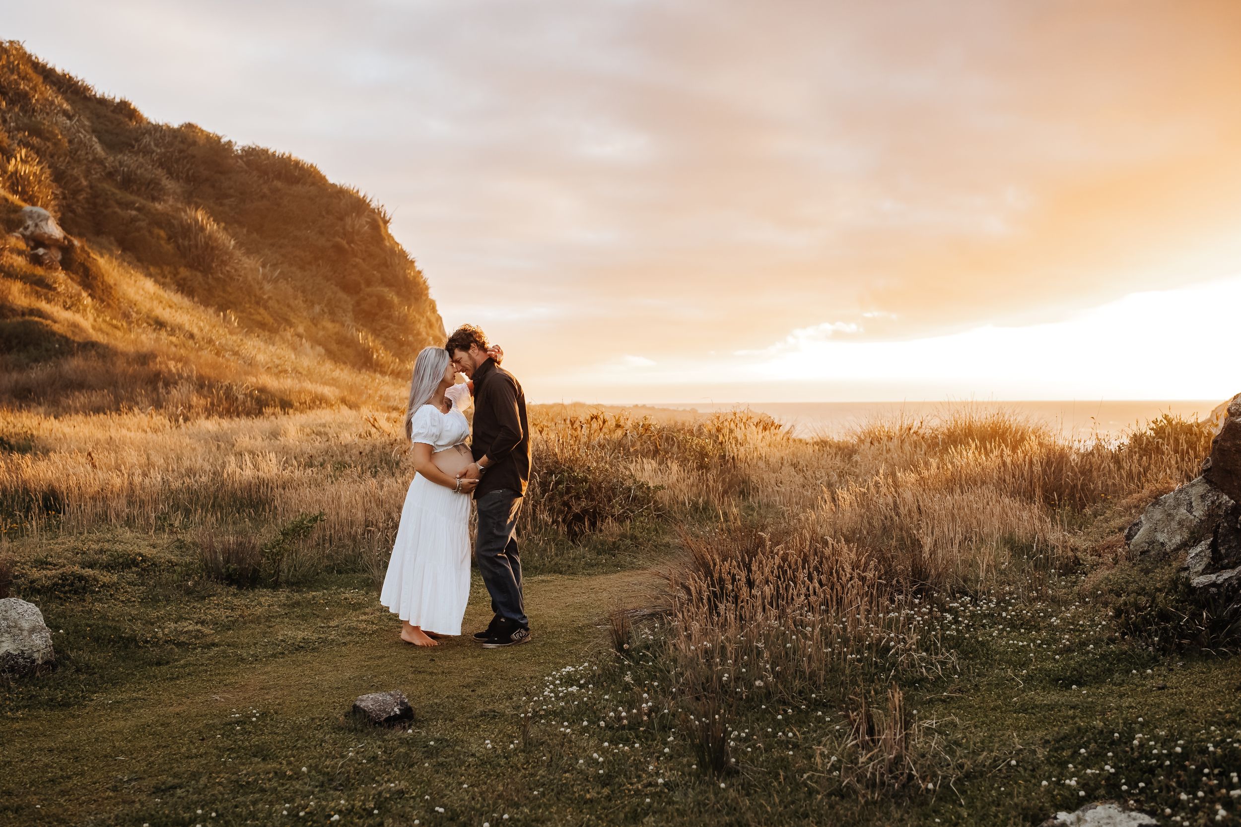 Maternity portrait of expectant mother on golden-hour beach Westport NZ