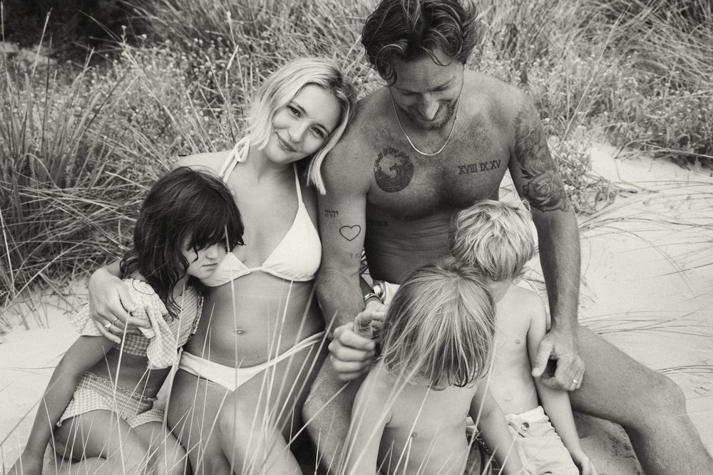 Family members share laughter and tender moments together while relaxing outdoors.