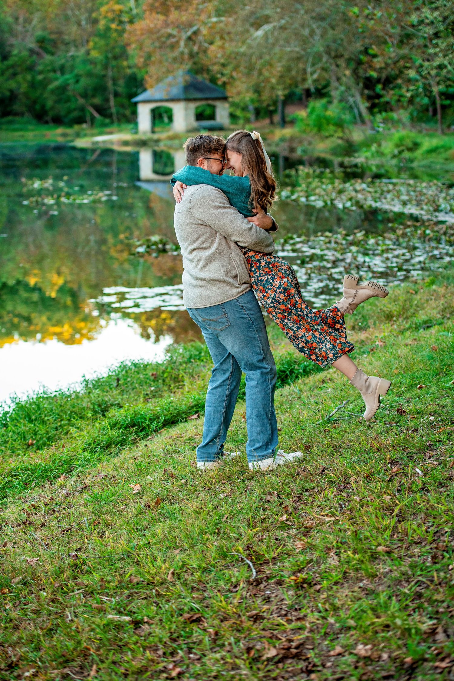Romantic outdoor couple photoshoot by lake during golden sunset.