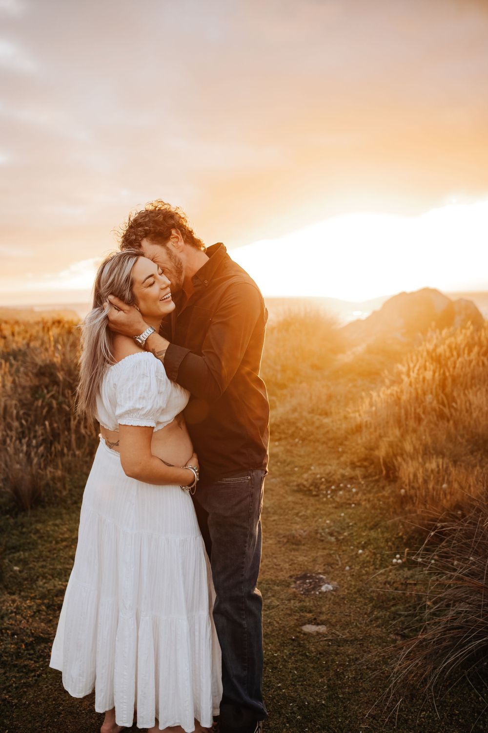 Maternity portrait of expectant mother during golden-hour at beach Westport NZ