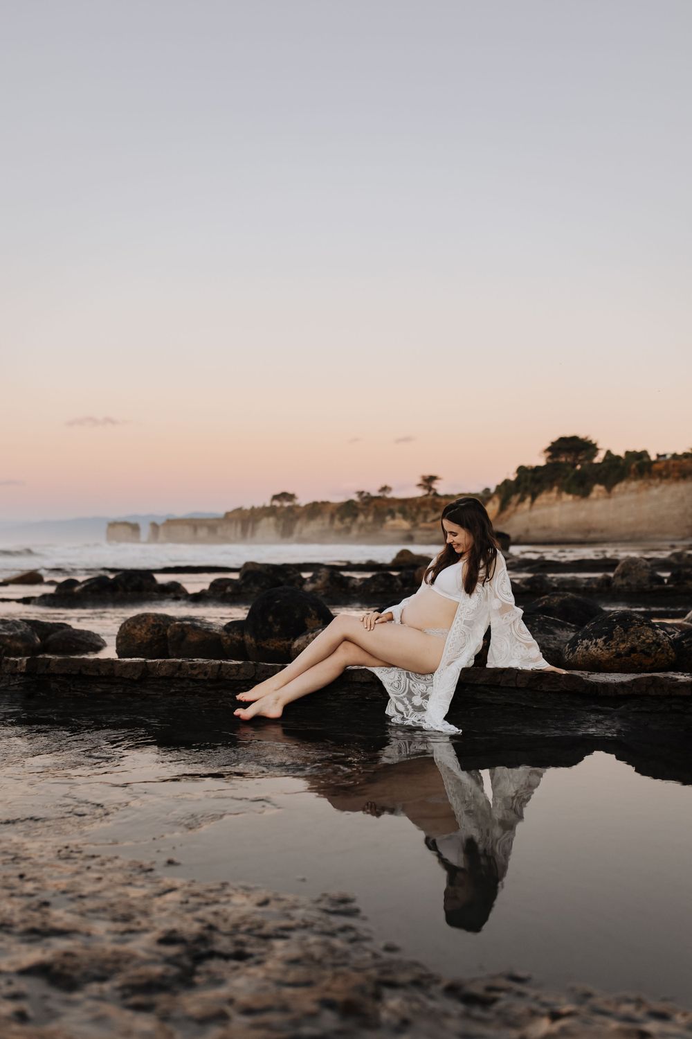 Maternity portrait of expectant mother during golden-hour at beach Westport NZ