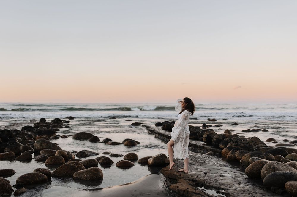 Maternity portrait of expectant mother during golden-hour at beach Westport NZ