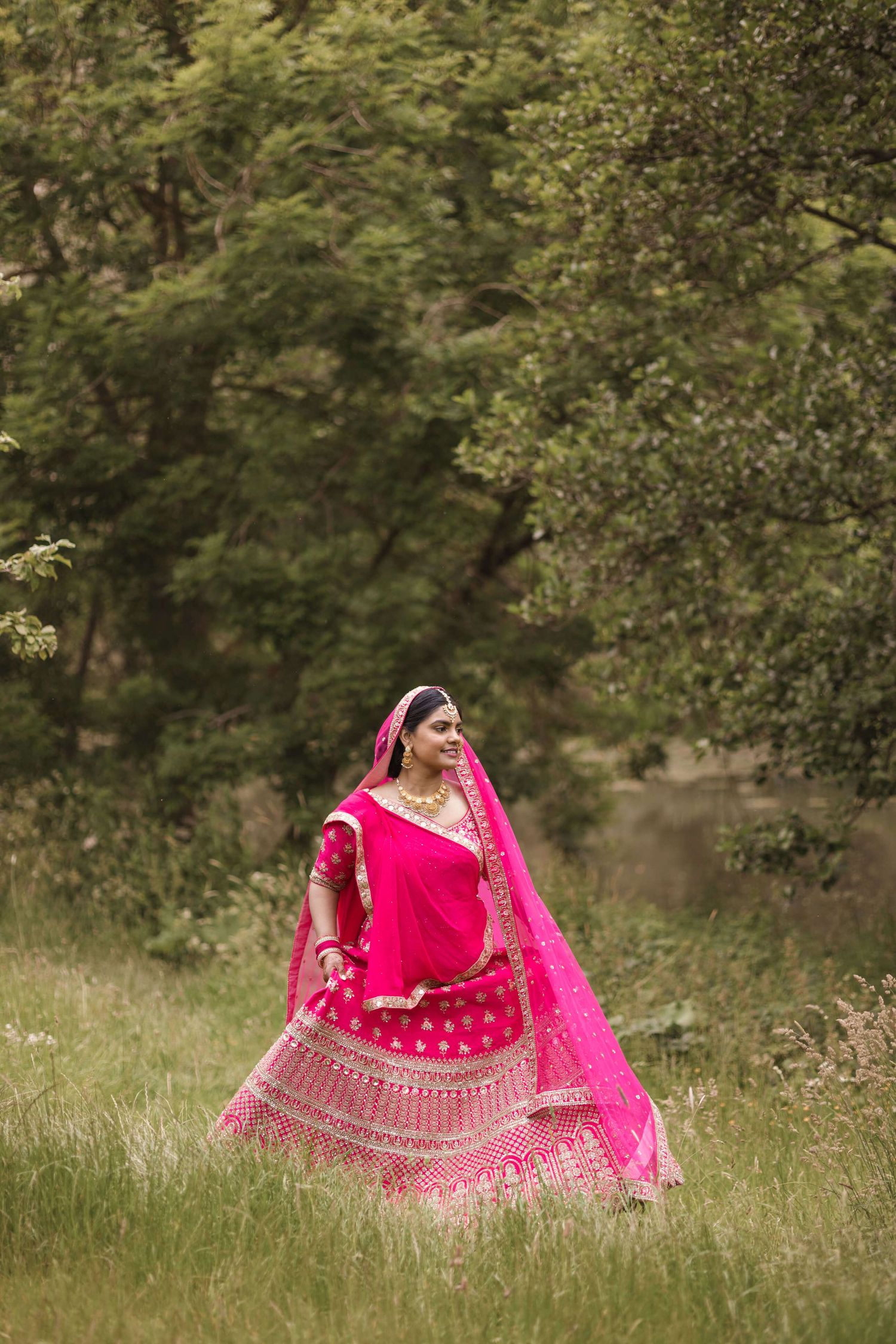 Joyful newly wed practising her mehendi dance in front of the photographers camera