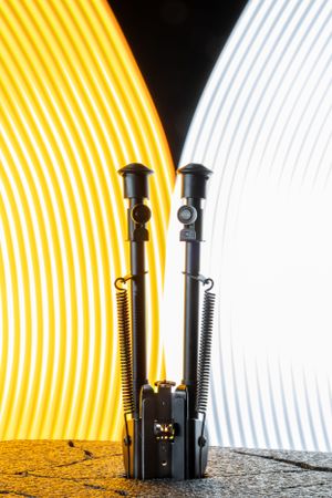 Abstract light painting with glowing yellow and white spiral patterns against a dark background.