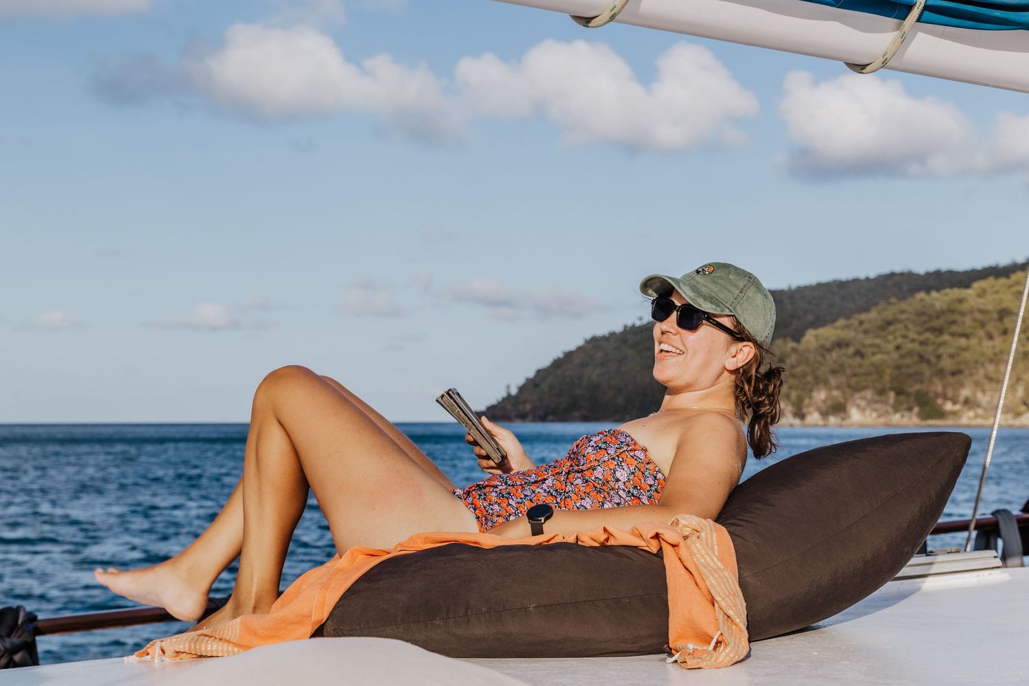 female holidayer relaxing on deck of sail boat commercial photoshoot Airlie Beach Whitsundays Great Barrier Reef