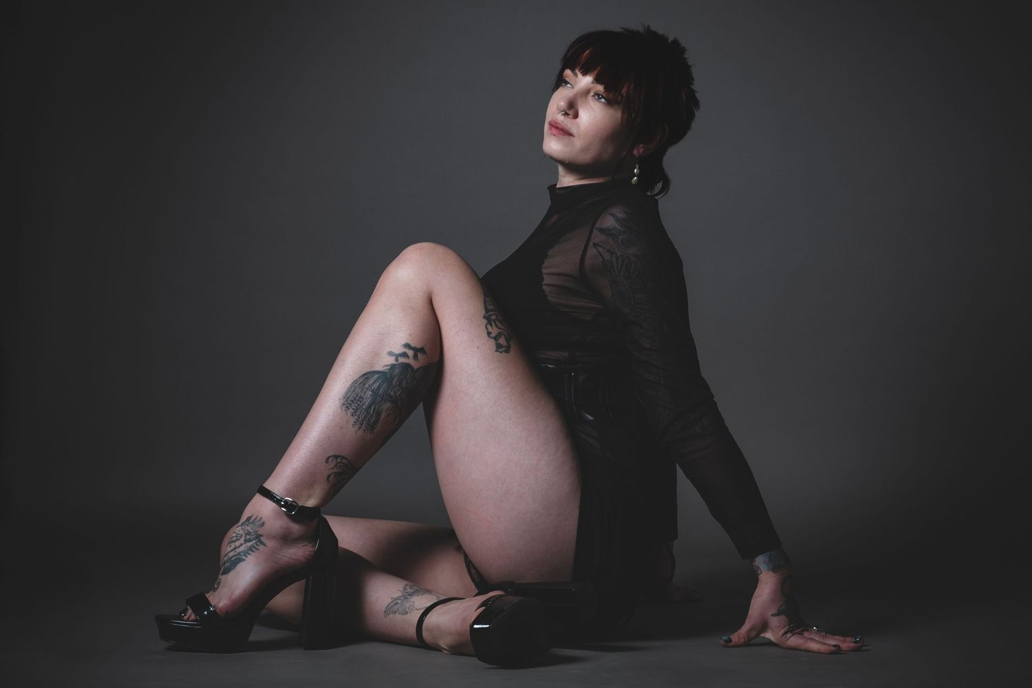 Artistic portrait on dark background featuring sheer black clothing.