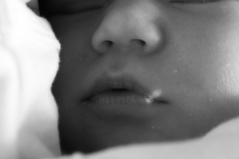 Black and white close-up of a sleeping newborn baby's nose and lips.