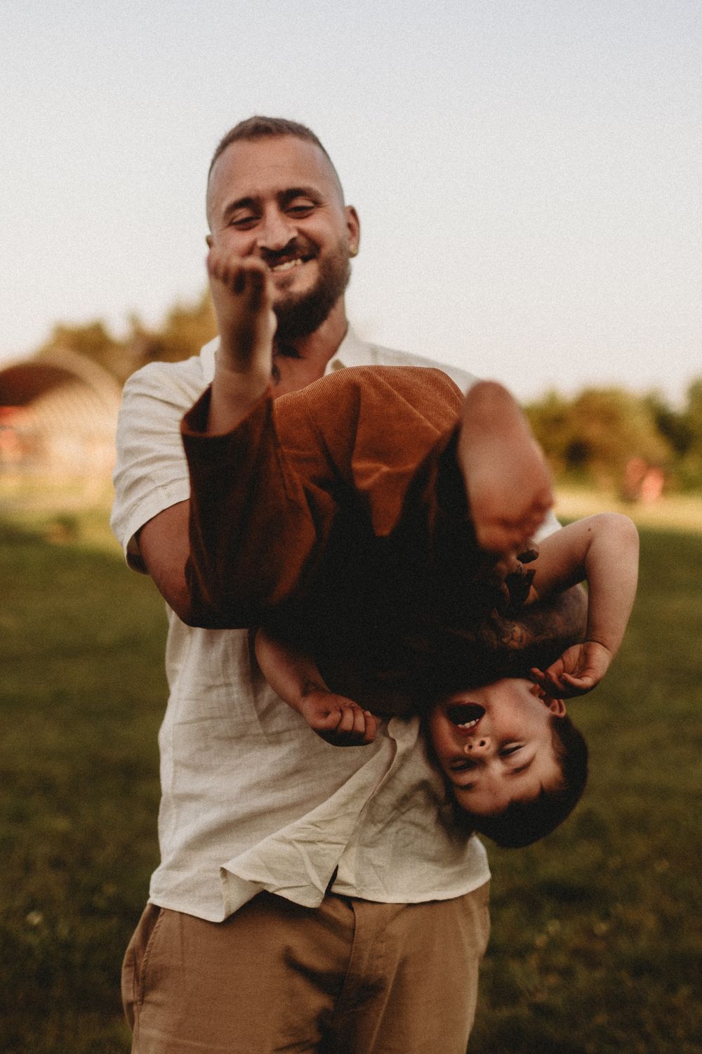 Playful outdoor photoshoot sequence showing joyful moments at sunset in a grassy field.