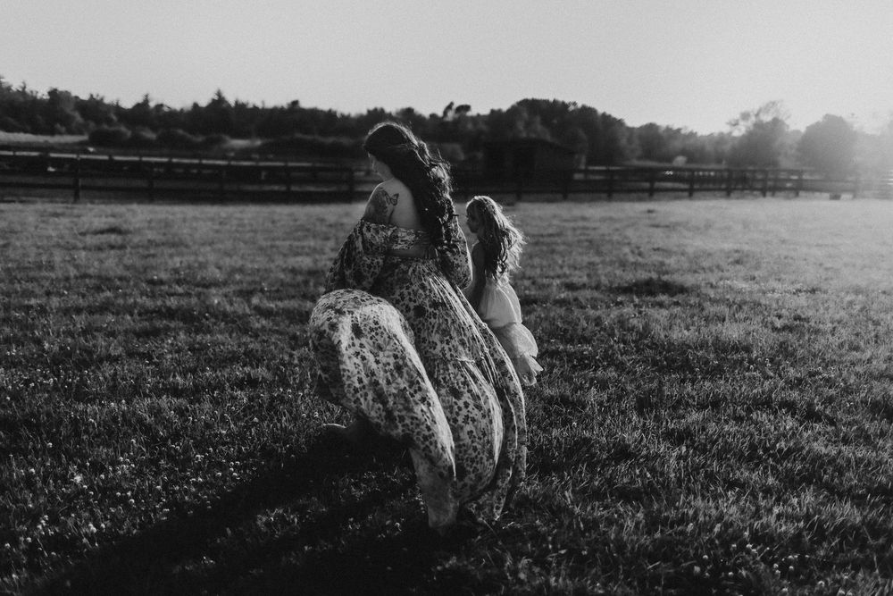 Silhouettes of family members playing in field during sunset.