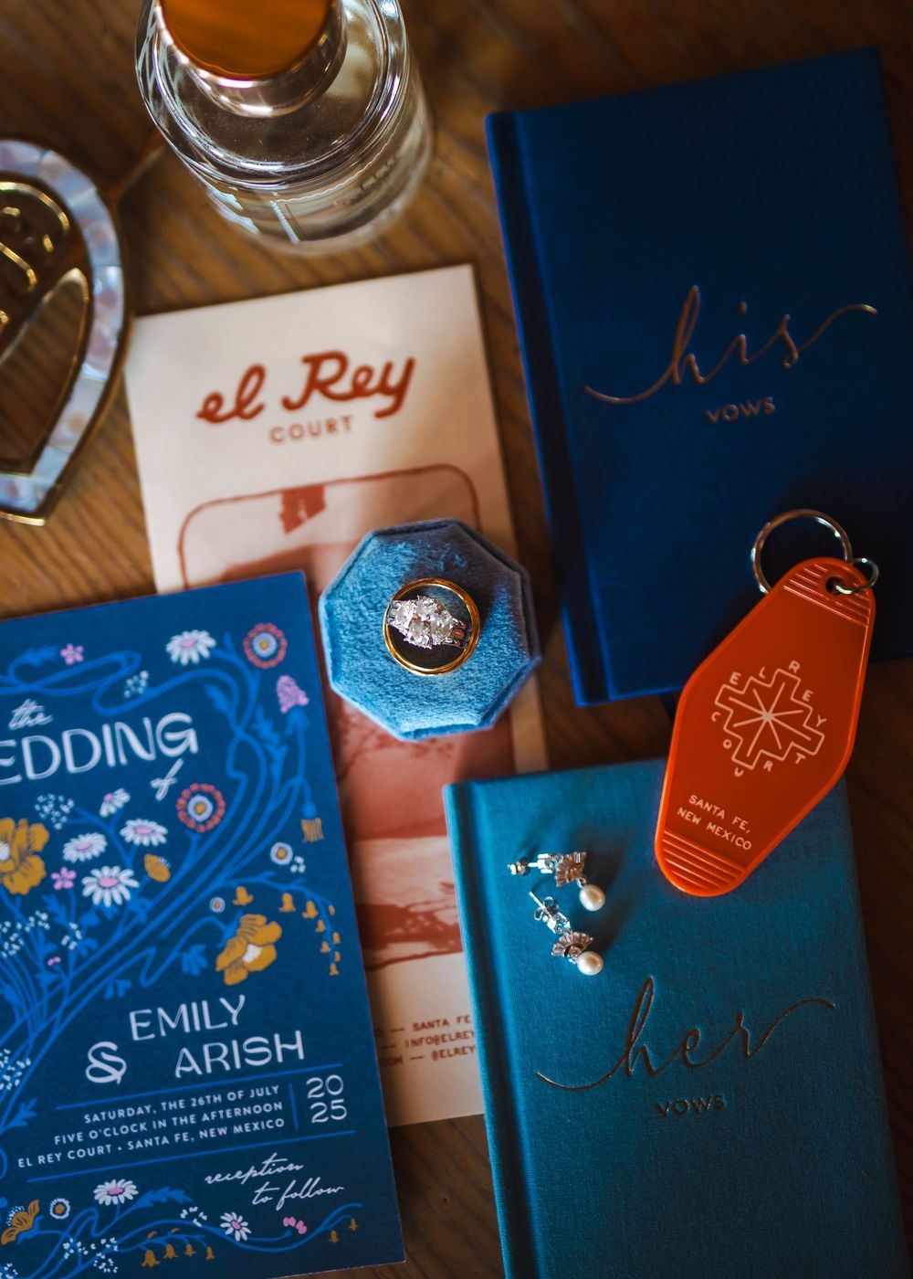 Several blue and orange themed teabag labels with drawings and branding designs lay arranged on a wooden surface.