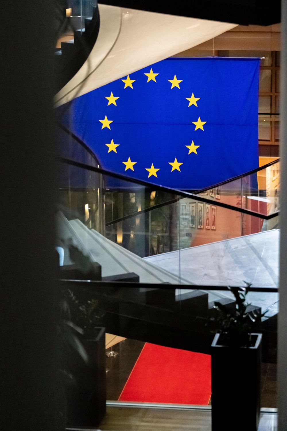 A series of photos showing the European Union flag and Polish flag displayed on building facades at night.