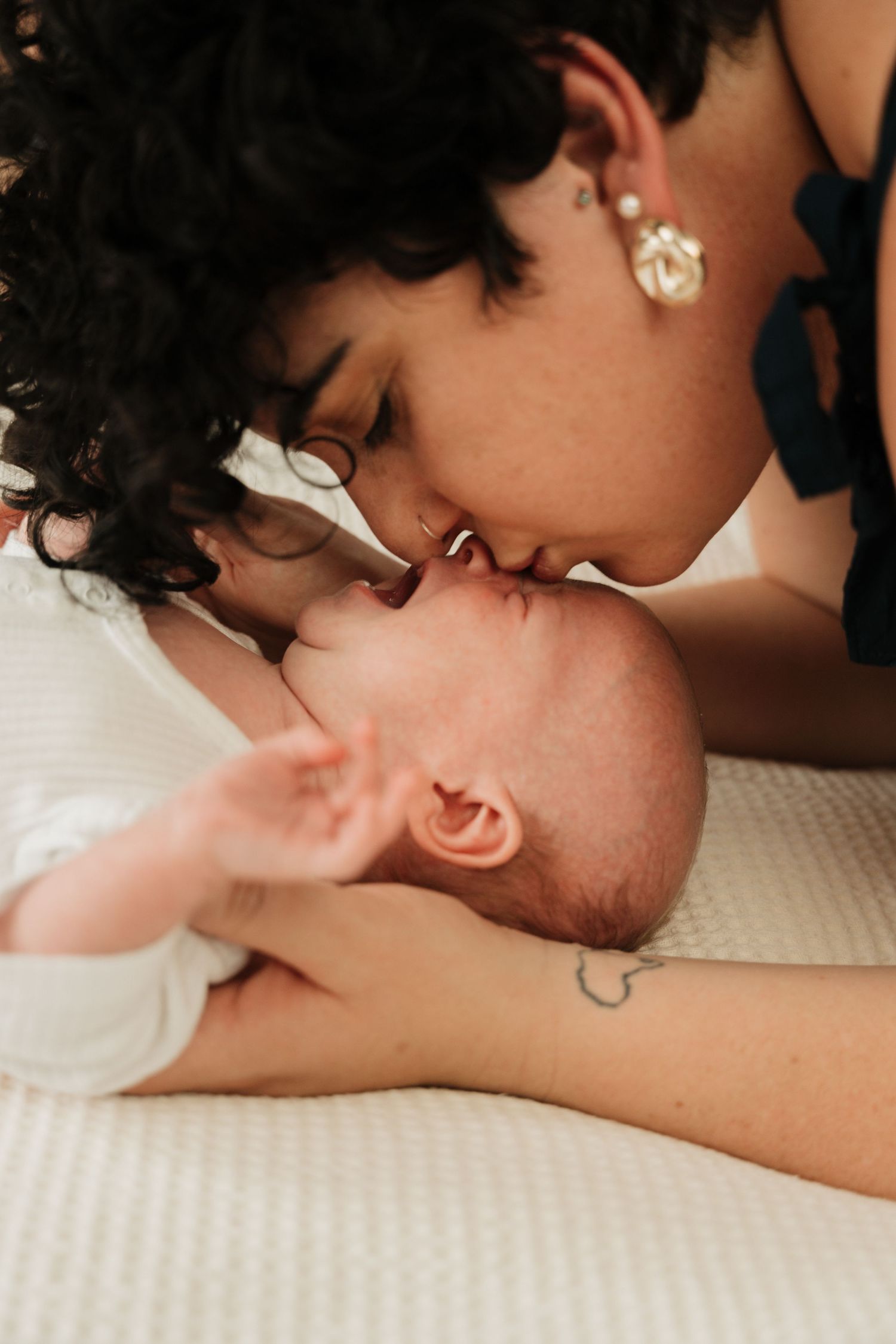 Intimate black and white close-up of baby and caregiver.