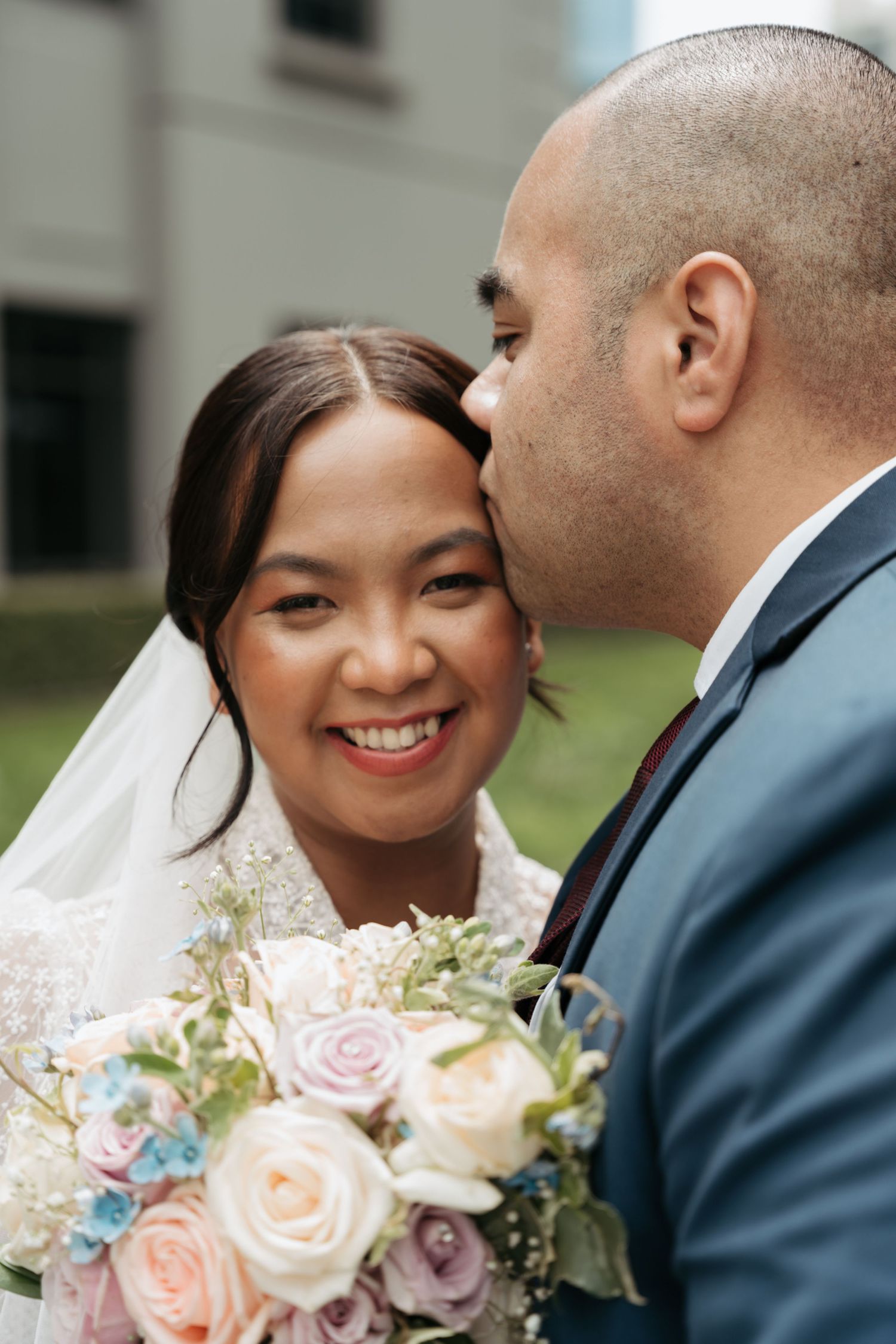 Elegant bridal portrait with pastel rose bouquet.