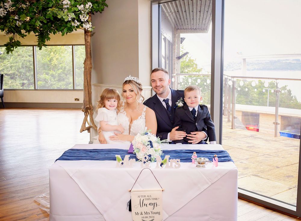 Bride and Groom posing with their children after their wedding ceremony. Family looking happy and relaxed at the Double Tree Hilton.