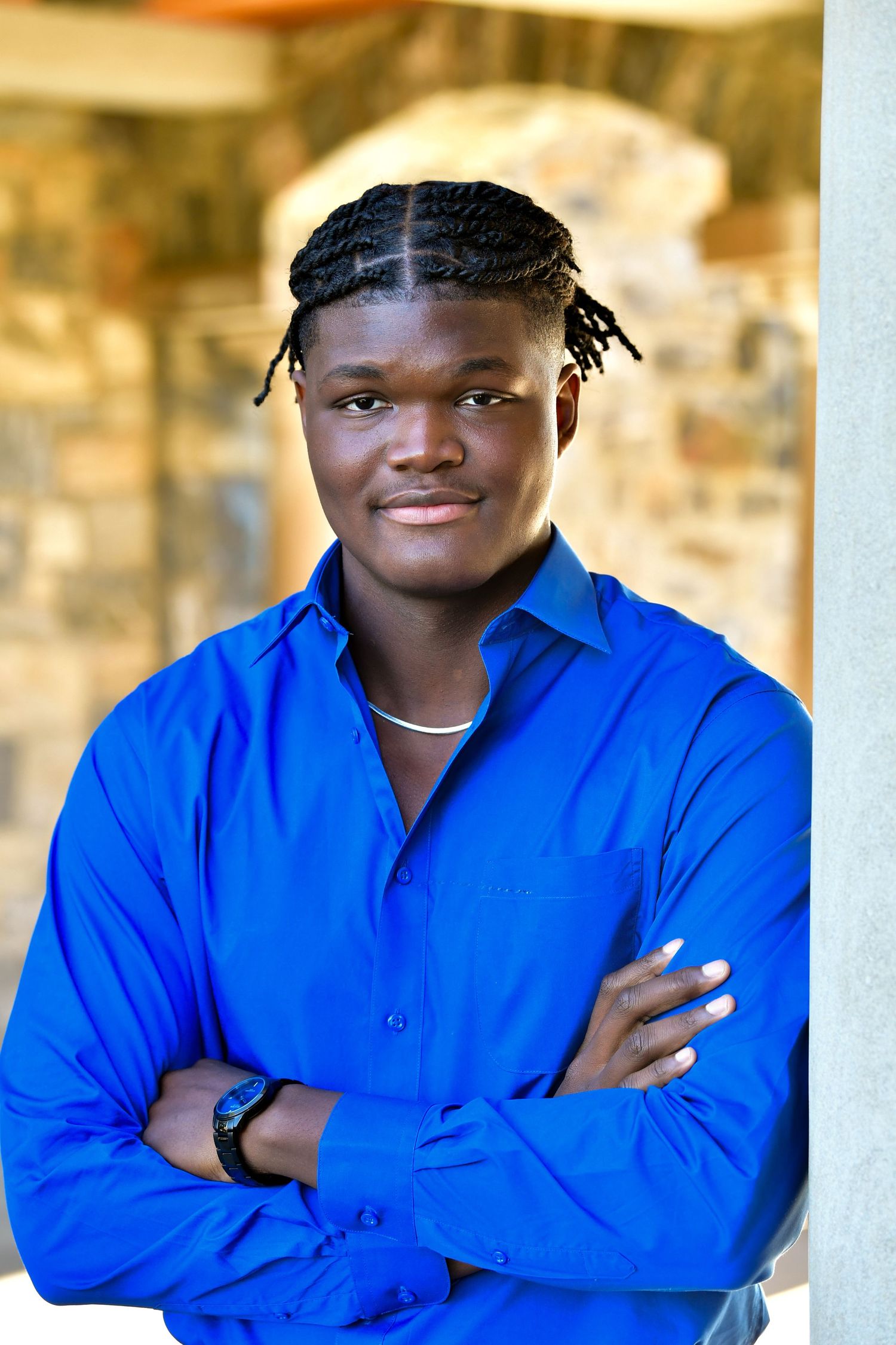 Professional headshot of person in vibrant blue shirt smiling at camera.