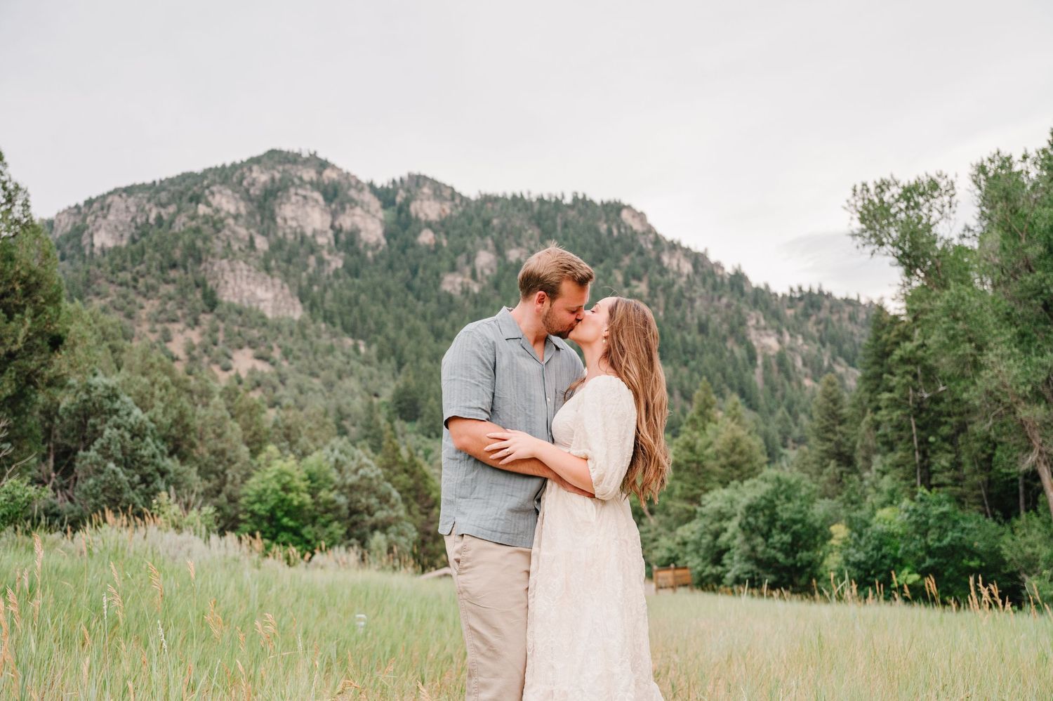 A romantic moment between a couple in a lush mountain meadow.