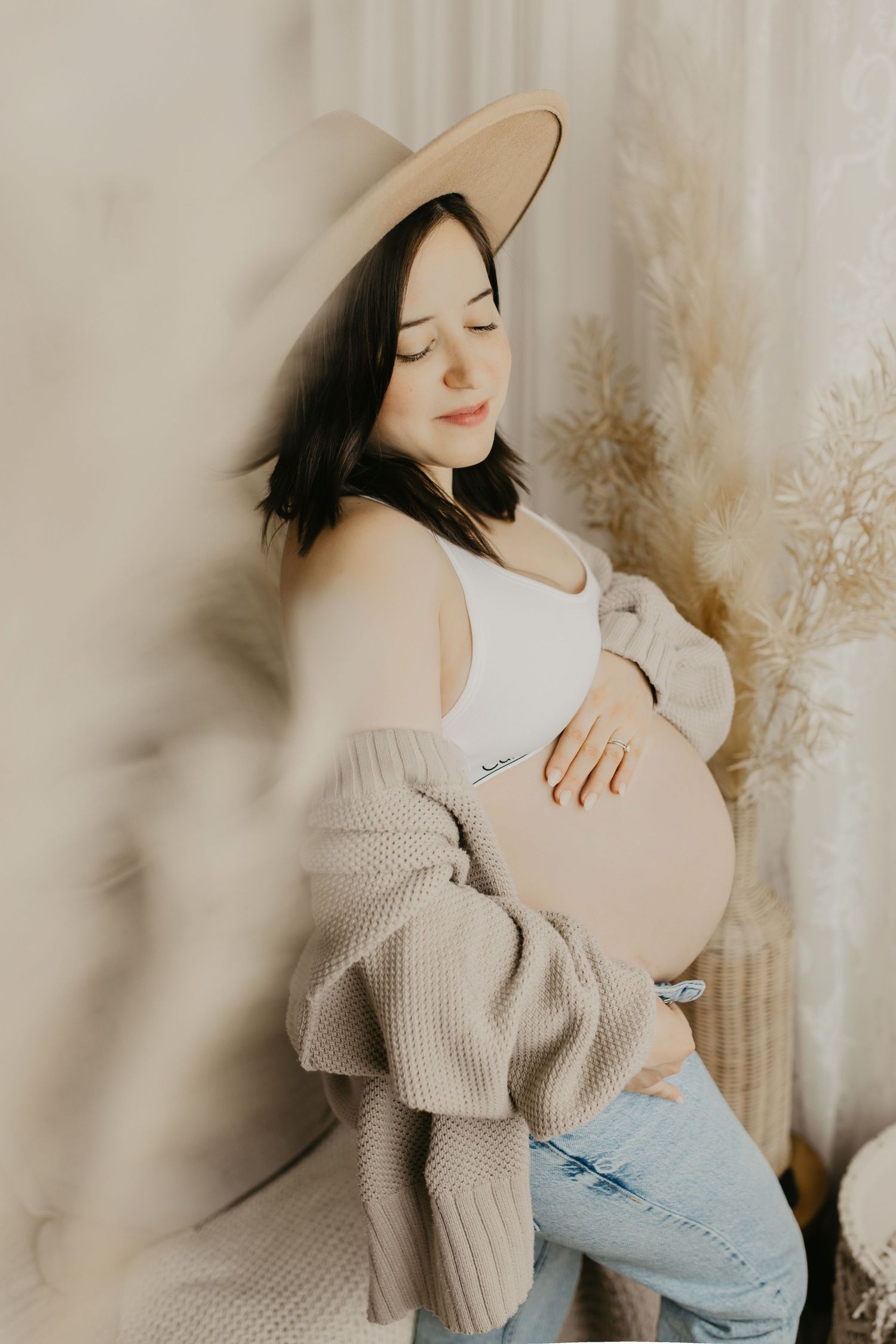 Artistic maternity portraits in soft beige tones with natural lighting.