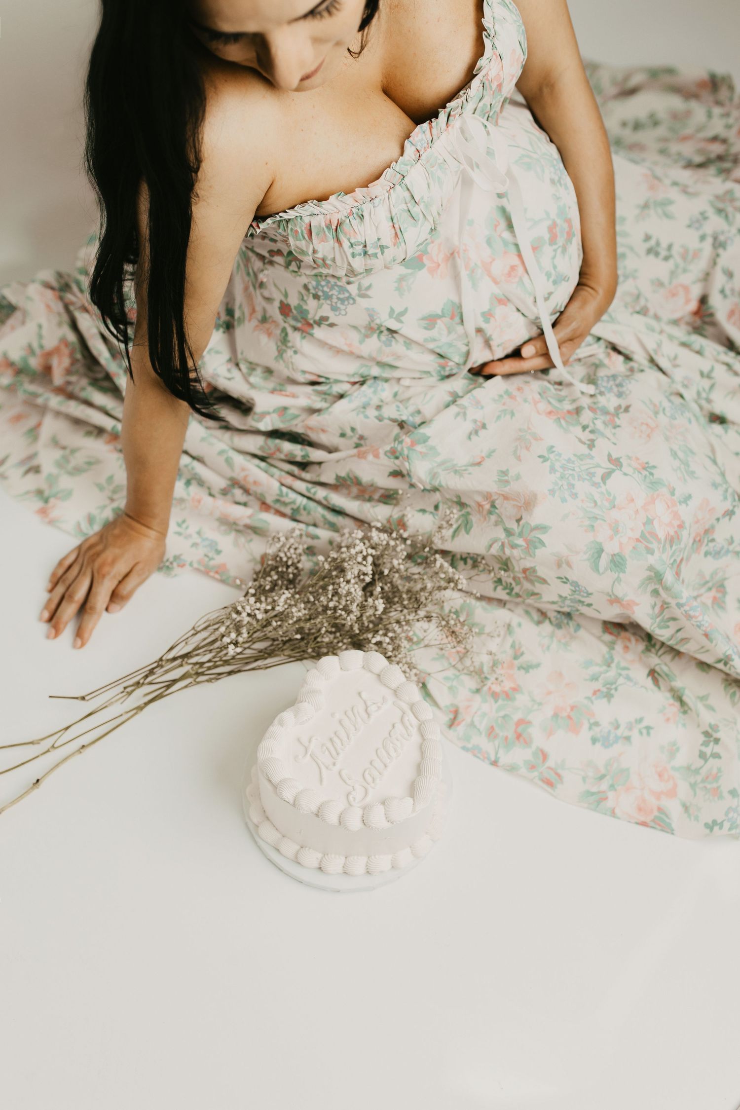 Romantic portrait setup with floral dress and dried flowers on white background.