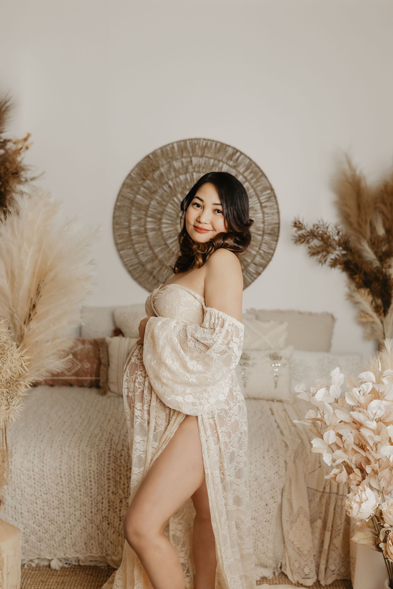Ethereal maternity boudoir photos with lace robe against neutral boho backdrop.