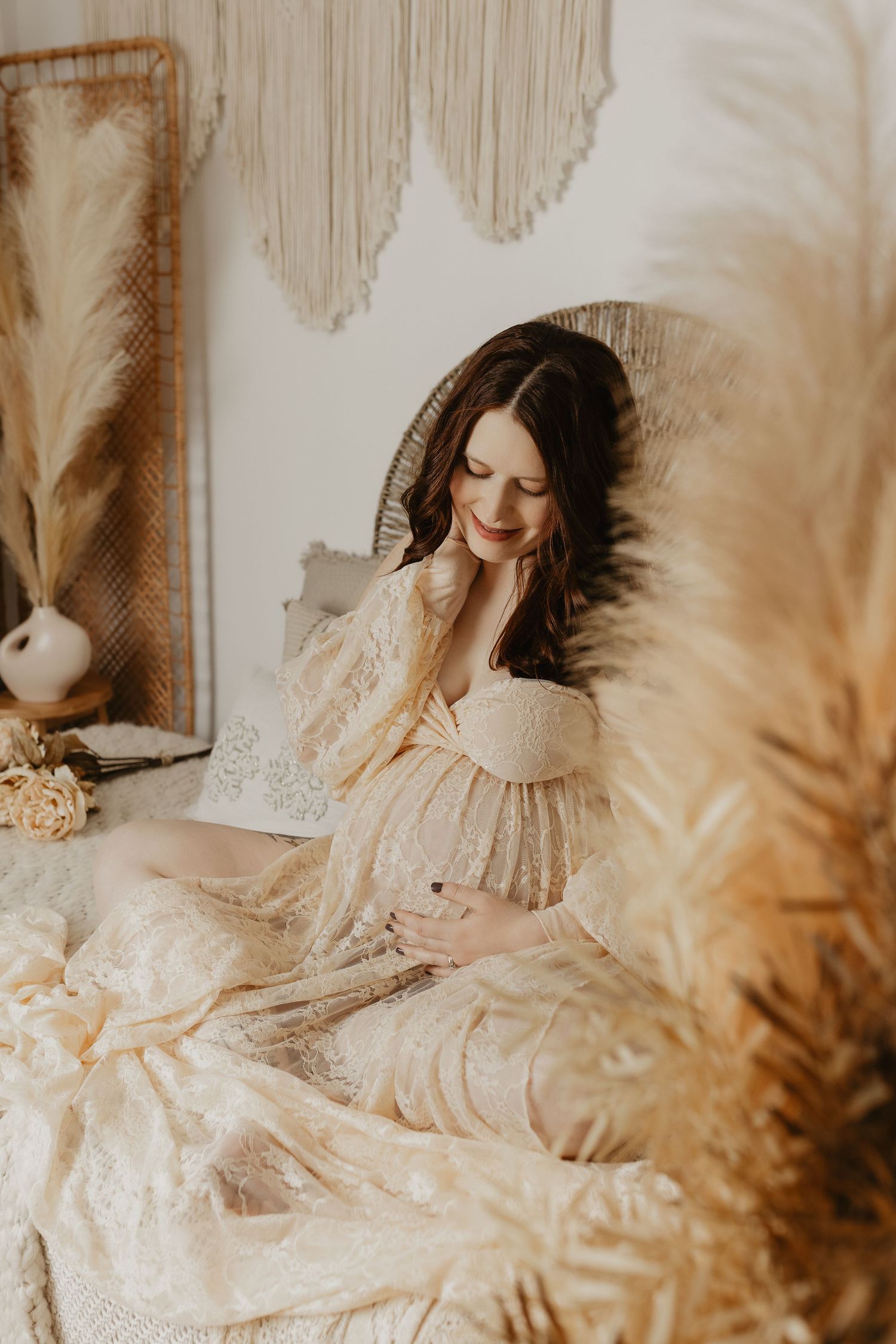 Dreamy maternity photos with lace details and pampas grass in soft natural lighting.